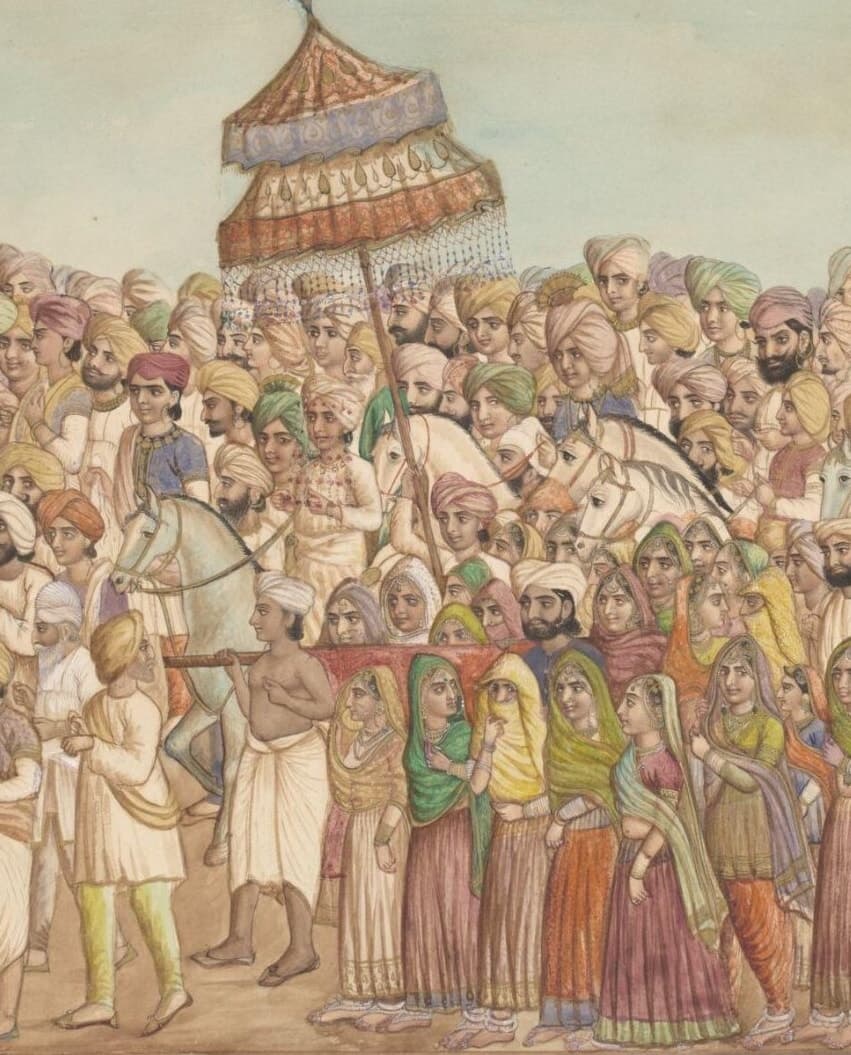 A Sikh wedding procession: the bridegroom on horseback under a tall embroidered parasol, the men of the barat in bright turbans around him, and women in green, yellow and rose veils walking in front