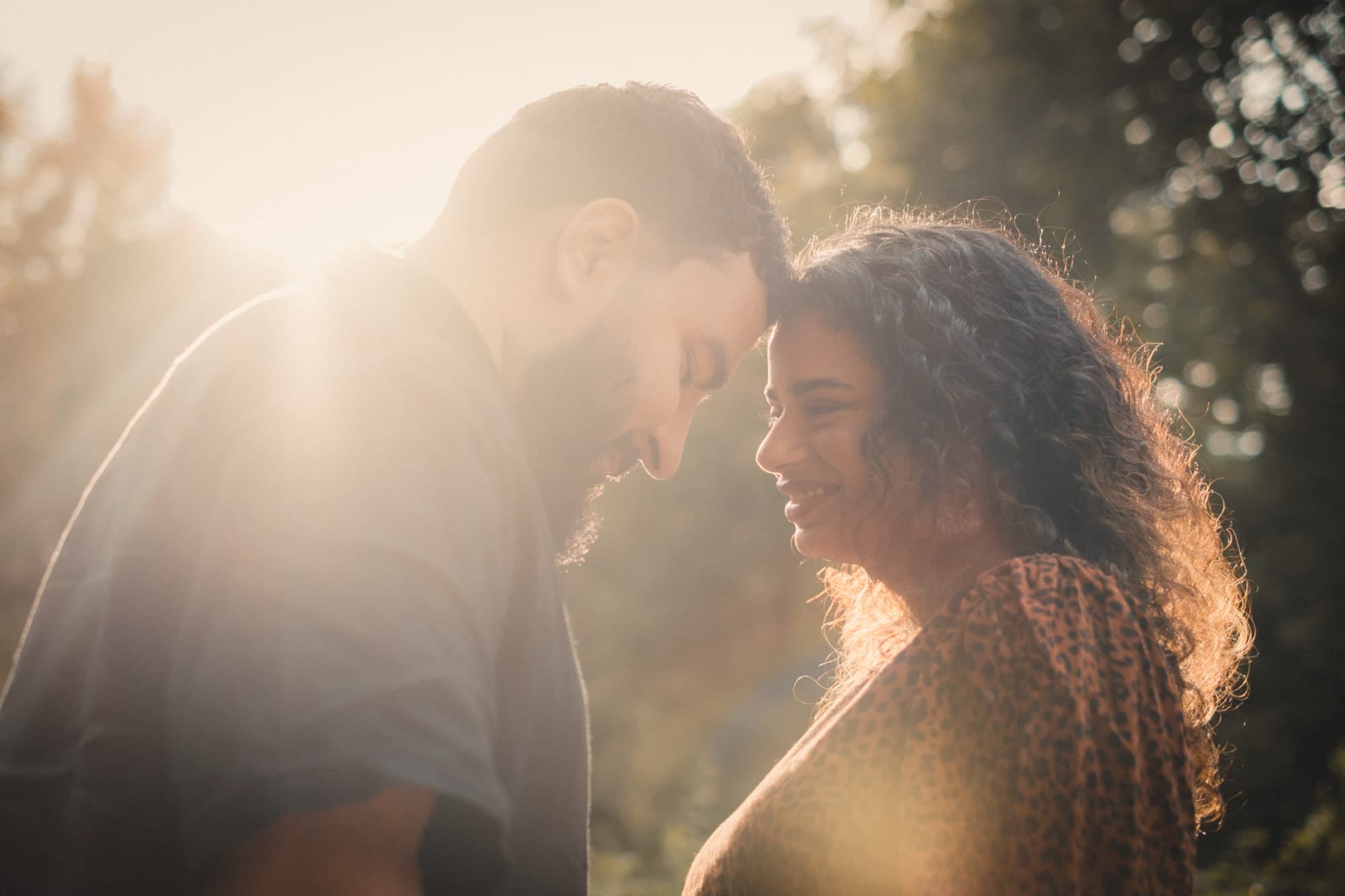 Talwinder and Ishmeet forehead to forehead in the low evening sun, both smiling